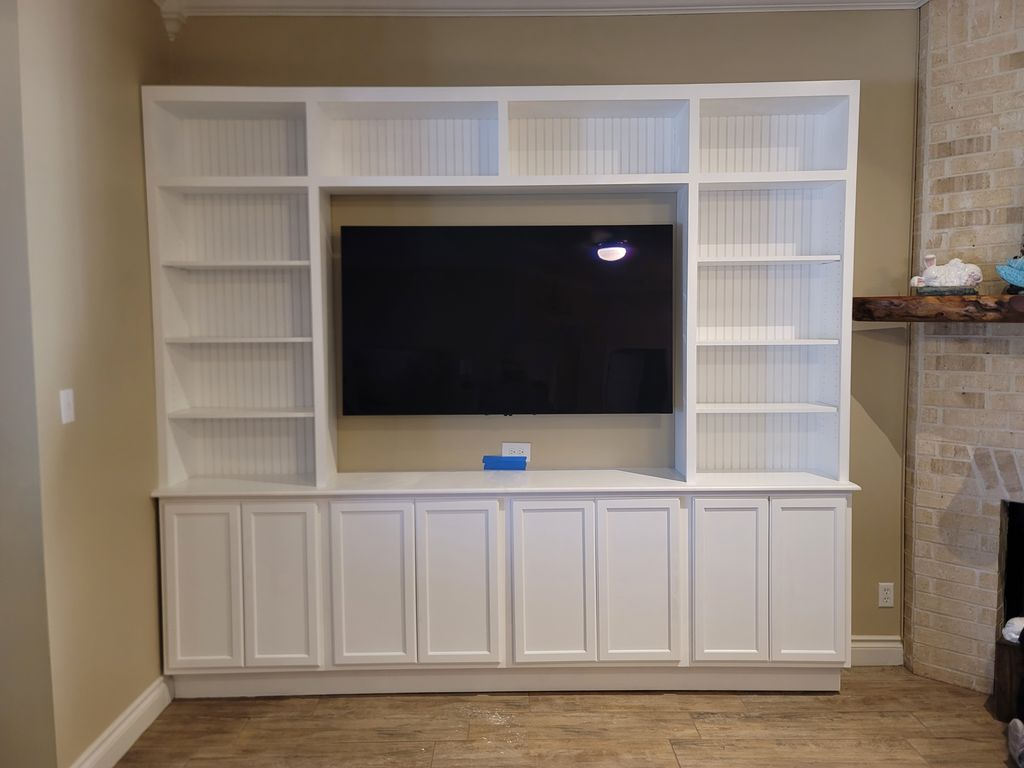 Custom white built-in media wall with open shelving and lower cabinets